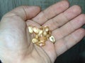 A person holds several vitamin D3 capsules in his palm