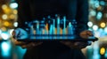A person holds a tablet with a glowing graph visualizing success progress data analysis and financial growth in a futuristic