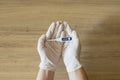 Person holds thermometer in his hands with surgical gloves