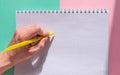 The person holds a yellow pen in his left hand and is about to write in a notebook. Royalty Free Stock Photo