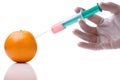 Person injecting liquid in orange