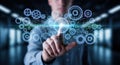 Person interacting with futuristic digital interface showing interlocking gears and data streams with glowing light Royalty Free Stock Photo