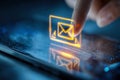 Person interacting with futuristic illuminated email icon on touchscreen device representing digital communication and technology Royalty Free Stock Photo