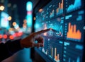 Person interacts with large digital dashboard showing analytics, charts. Night city lights blur background. Modern tech display.