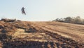 Person, jump and dirt track of professional motorcyclist in the air for trick, stunt or race on outdoor terrain. Expert Royalty Free Stock Photo