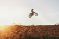 Person, jump and motorcyclist in the air on mockup with sunset for trick, stunt or ramp on outdoor dirt track. Expert Royalty Free Stock Photo