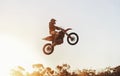 Person, jump and motorcyclist in the air with sunset on mockup for trick, stunt or ramp on outdoor dirt track. Expert Royalty Free Stock Photo