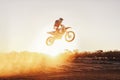 Person, jump and motorcyclist with sunset for trick, stunt or ramp on mockup or outdoor dirt track. Expert rider on Royalty Free Stock Photo
