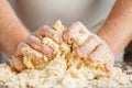 Person kneading dough on wooden table Royalty Free Stock Photo