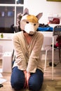 A woman kneels on the ground wearing a fox mask Royalty Free Stock Photo