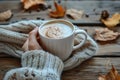 Person in knitted sweater holding a mug of frothy coffee, symbolizing comfort and warmth in autumn