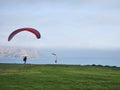 Person learning paragliding in gardens facing the sea Royalty Free Stock Photo