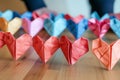 person lining up heart origamis for a photo shoot