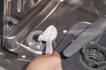 Person loading dishwasher salt into modern dishwasher for efficient cleaning Royalty Free Stock Photo