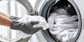 The person loading fresh white laundry into a modern washing machine. AI generated image Royalty Free Stock Photo