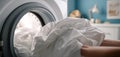 The person loading freshly washed linens into the washing machine for cleaning. AI generated image Royalty Free Stock Photo