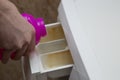 A person loads a liquid stain remover into a washing machine