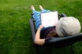 Person Lounging in Lawn Chair Relaxing and Reading Book