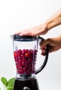 Person making cherry smoothie with a blender