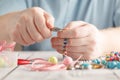 Person making earings from colorful beads and needles Royalty Free Stock Photo