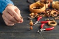 Person making jewelry using wire, chains and beads and other materials with craft tools