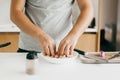 Person marinating slices of chicken fillet in spices at wooden board on modern white kitchen. Process of making home pizza, hands Royalty Free Stock Photo