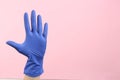 Person in medical gloves on pink background, closeup of hand. Space for text Royalty Free Stock Photo