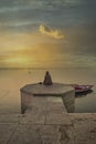 A person is watching beautiful sunrise on the bank of river ganga at ghats of varanasi while meditating Royalty Free Stock Photo