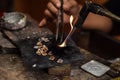 A person is melting silver to make jewellery.