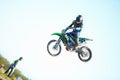 Person, motorcycle and air stunt in blue sky as professional in action, competition or fearless. Bike rider, off road