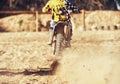 Person, motorcyclist and dust with dirt bike on track for race, extreme sports or outdoor competition. Rear view of Royalty Free Stock Photo