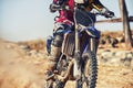 Person, motorcyclist and track with dirt bike for race, extreme sports or outdoor competition. Closeup or legs of expert Royalty Free Stock Photo