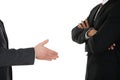 Person offering handshake to businessman with arm crossed