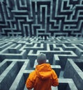 Person in orange jacket navigating complex concrete maze, exploring intricate pathways and challenges, contemplating