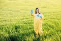 Person in overalls holds paper with a call to save the planet while standing on green field on sunset and the other hand shows a Royalty Free Stock Photo