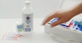 A person packing first aid items next to a bottle of PSP isopropyl alcohol 99% USP Care on a white table