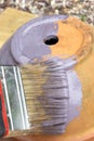 Person painting a terracotta flower plant pot purple,  with a paint brush. Royalty Free Stock Photo