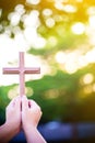 Person palm hands to hold holy cross, crucifix to worship. Royalty Free Stock Photo