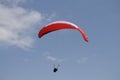 Person paragliding above a beautiful mountainous landscape