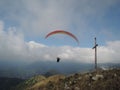 Person paragliding in a free fly in Europe in Alps mountains with blue sky in the background