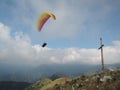 Person paragliding in a free fly in Europe in Alps mountains with blue sky in the background