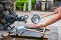 Person perform ablution purification known as temizu or chozu in Kyoto, Japan. Royalty Free Stock Photo