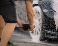 Person photographing the wheels of a car at the carwash