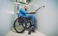 Person with a physical disability in a wheelchair using lift in building