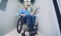 Person with a physical disability in a wheelchair using lift in building