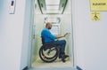 Person with a physical disability in a wheelchair using lift in building