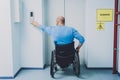 Person with a physical disability in a wheelchair using lift in building