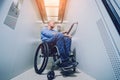 Person with a physical disability who uses wheelchair using lift in building