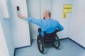 Person with a physical disability who uses wheelchair using lift in building