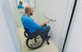 Person with a physical disability who uses wheelchair using lift in building